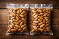 Two bags of peanuts on a wooden surface